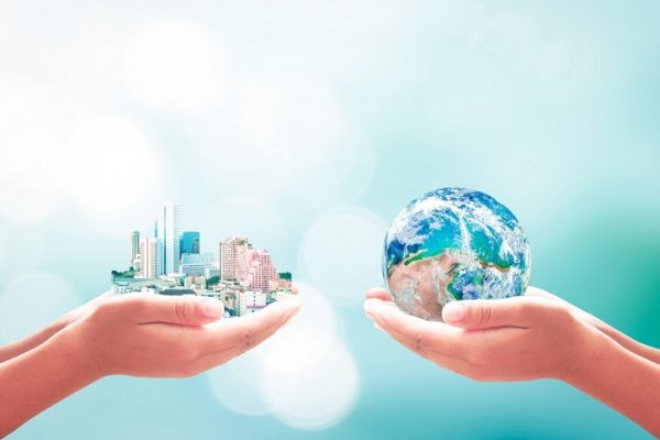 Two human hands holding earth global and big city on blurred blue nature background. Elements of this image furnished by NASA